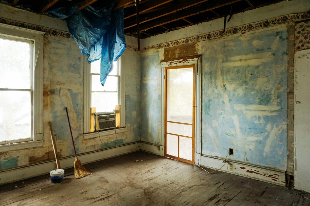 pexels-photo-3562689-3562689 An empty room in an abandoned house with peeling walls and construction tools.